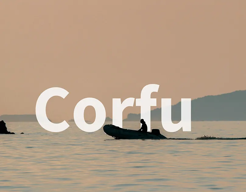 Small boat on calm sea in the evening light, Corfu, Greece