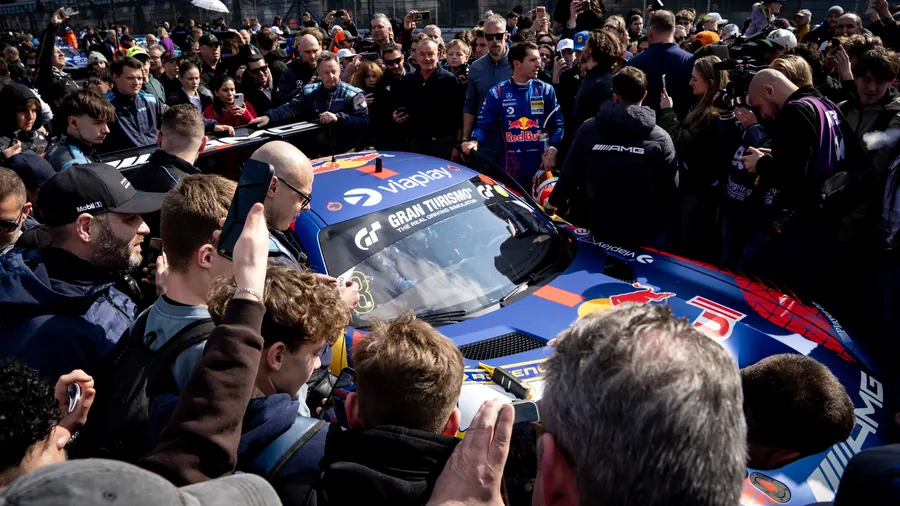 Fans crowding around the Verstappen.com Racing Mercedes-AMG GT3 in the pit lane